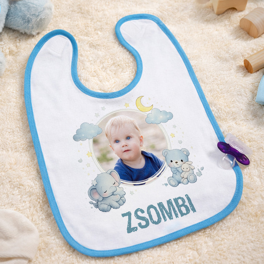Egyedi fényképes, világoskék szegélyű baba előke saját névvel és fotóval, macis mintával, fehér alapon.