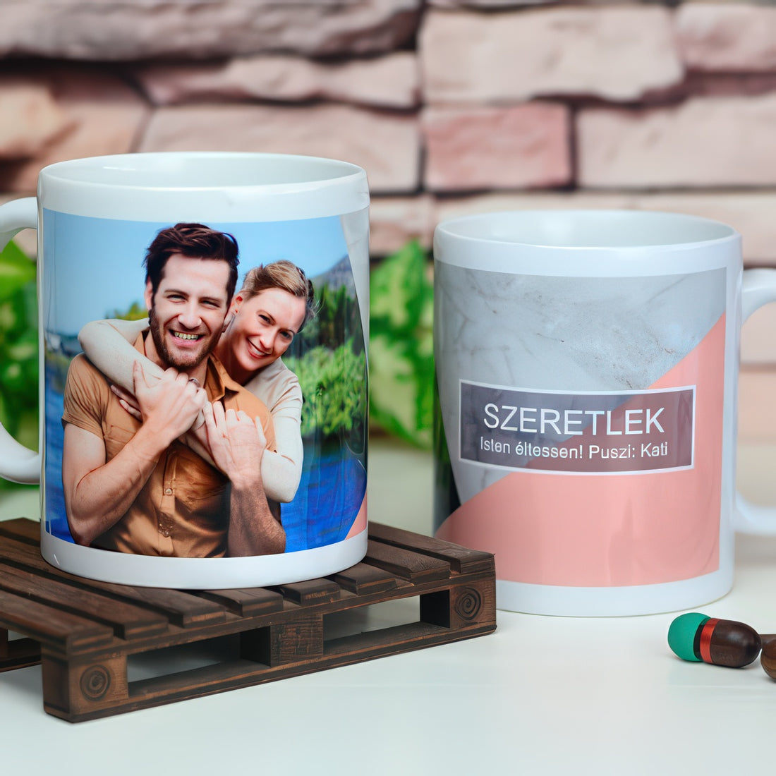 Két fényképes bögre, az egyiken egy ölelkező pár fotója, a másikon márvány és rózsaszín mintán Szeretlek felirat