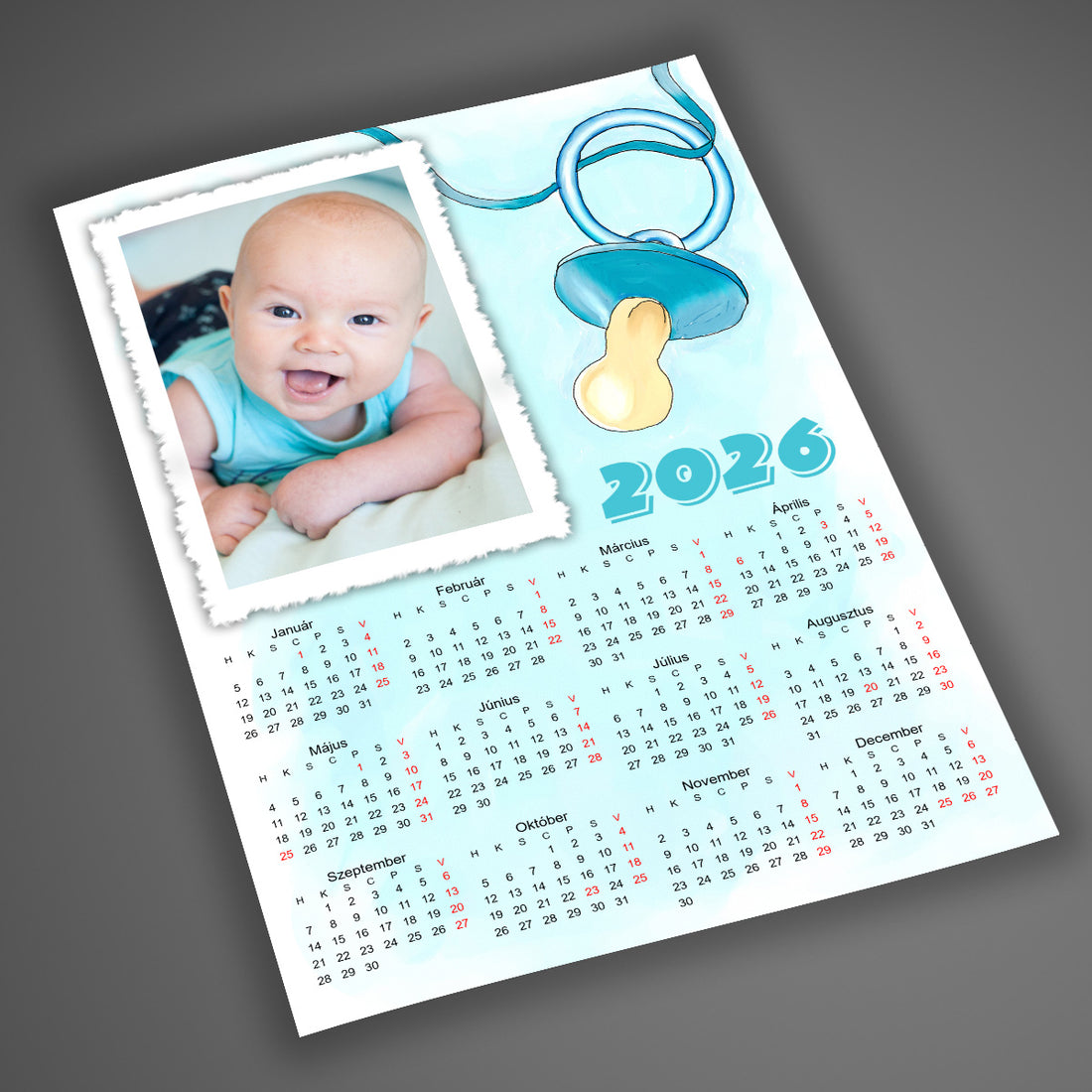 A4-es, laminált, egyedi fényképes falinaptár 2026 babás dizájnnal, pasztell kék háttérrel és cumi grafikával, kisbabás családoknak, saját fotóval.