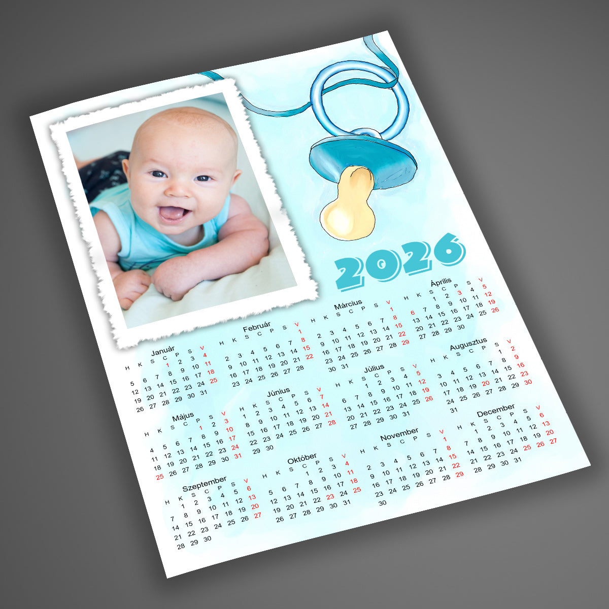 A4-es, laminált, egyedi fényképes falinaptár 2026 babás dizájnnal, pasztell kék háttérrel és cumi grafikával, kisbabás családoknak, saját fotóval.