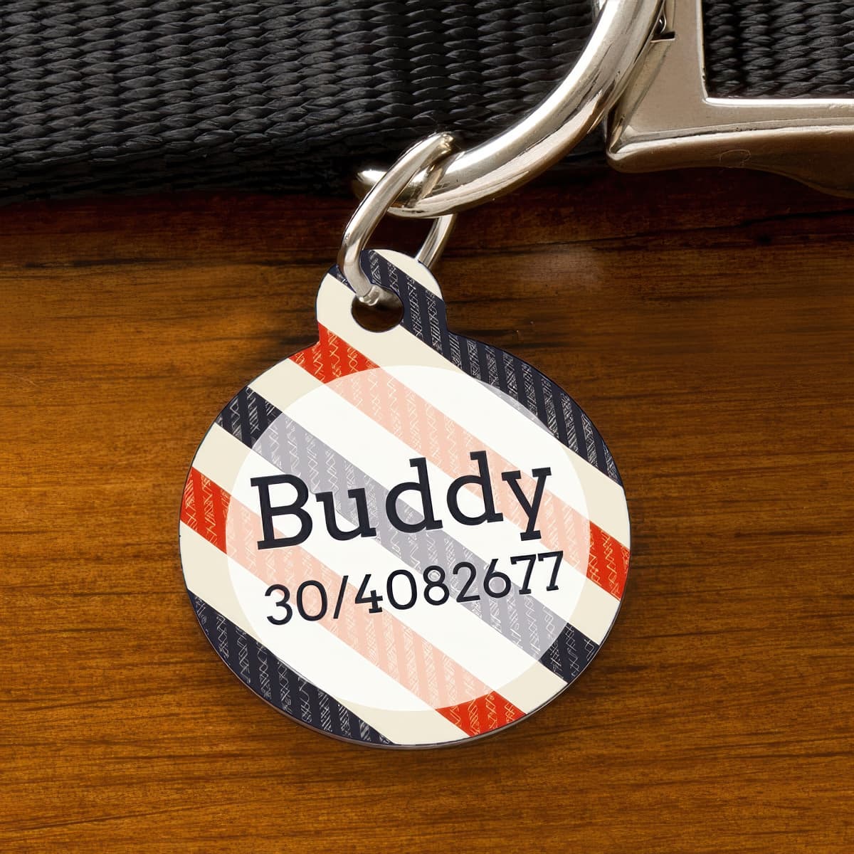 Kör alakú, sötétkék-piros-krém csíkos kutyabiléta „Buddy” névvel és telefonszámmal, nyakörvre akasztva