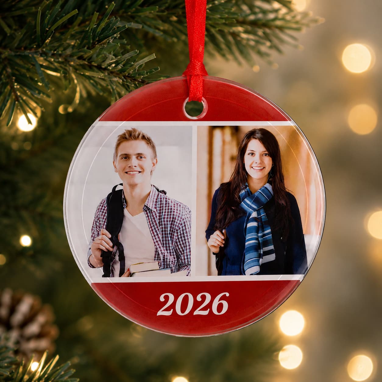 Egyedi fényképes üveg karácsonyfadísz két saját fotóval és 2026-os évszámmal, piros szalaggal a karácsonyfán.