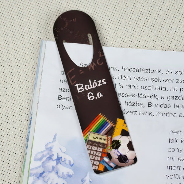 Iskolás mintájú egyedi könyvjelző névvel és osztálymegjelöléssel, ahol a név és az osztálynév szabadon cserélhető, praktikus és személyes ajándék diákoknak.