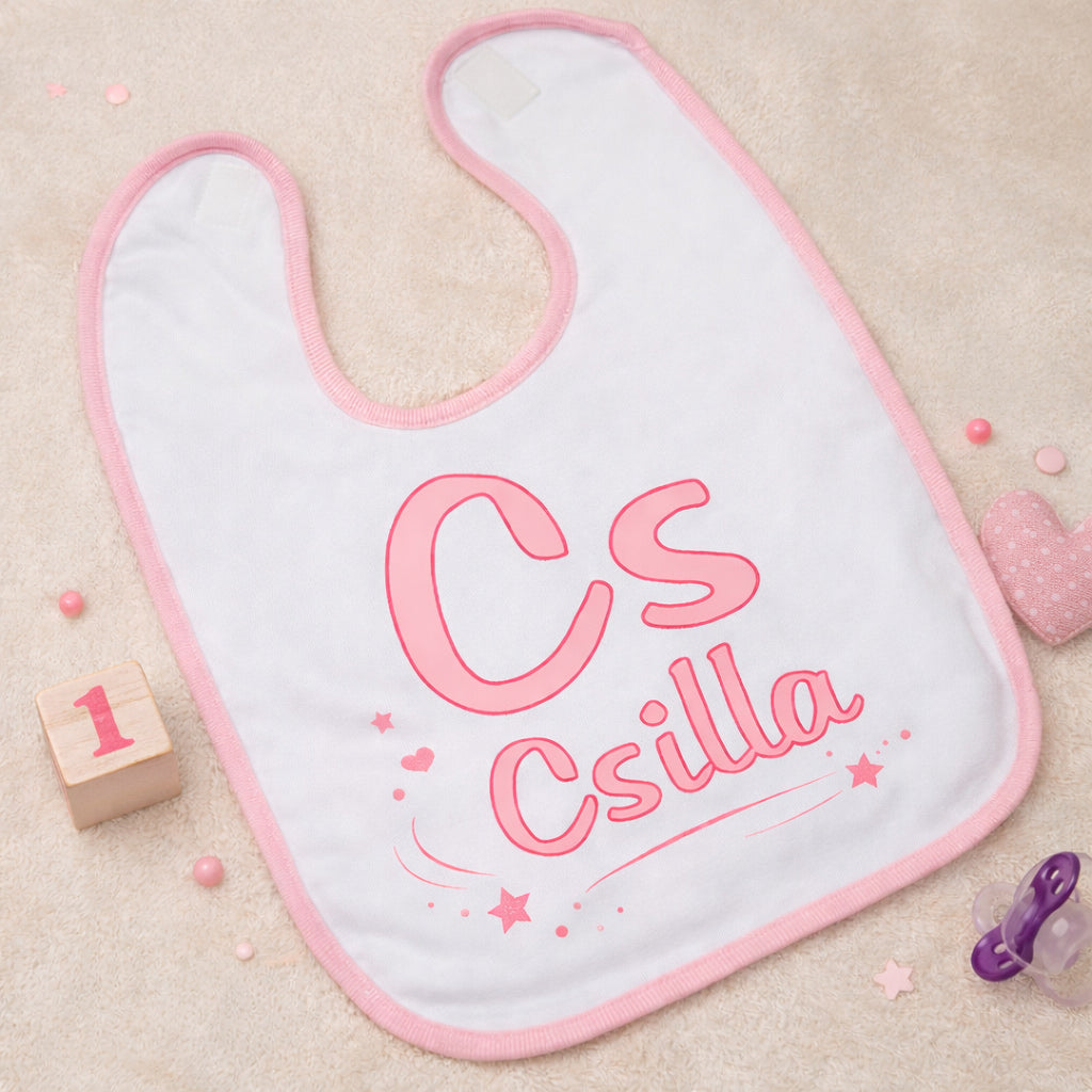 Egyedi  monogramos bébi előke grafika pasztell rózsaszínben, apró csillag- és szívmotívumokkal, átlátszó háttéren.